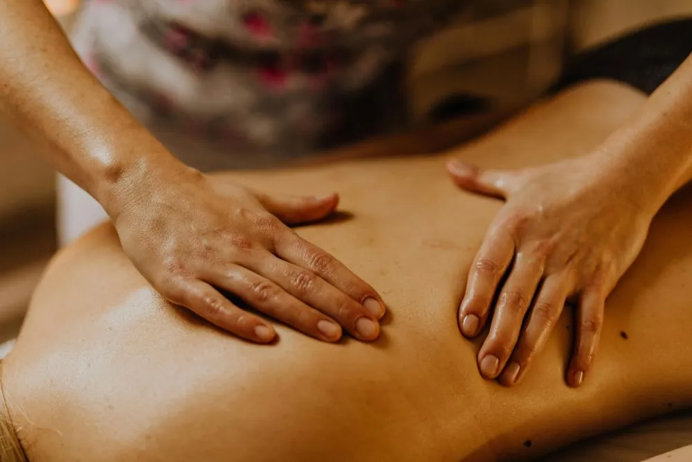 A therapist performing a lymphatic drainage massage on a client's arm.